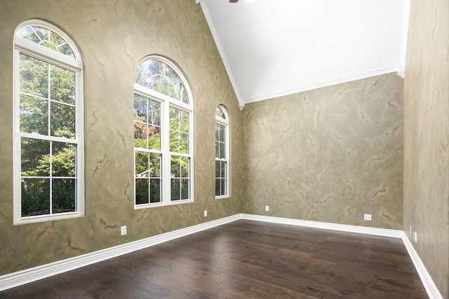 empty room featuring dark hardwood / wood-style floors, plenty of natural light, ornamental molding, and vaulted ceiling