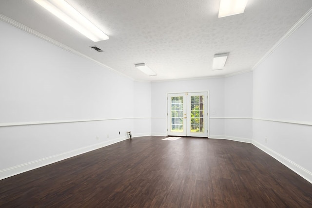 spare room featuring crown molding, french doors, dark wood-type flooring, and a textured ceiling