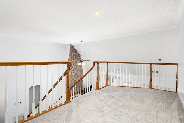 unfurnished room with ceiling fan, carpet, and a textured ceiling