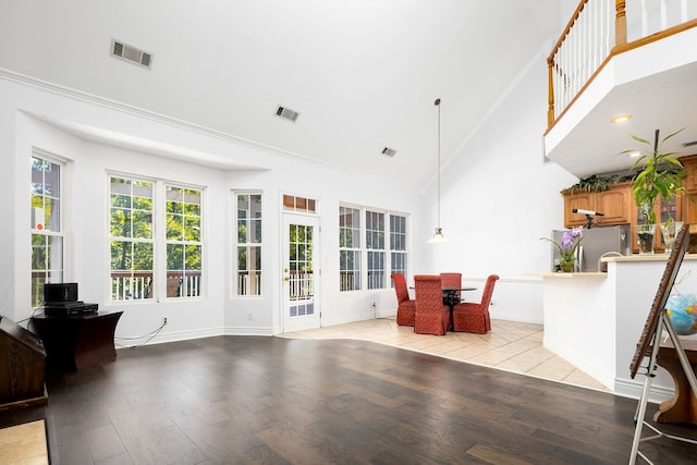 interior space with light hardwood / wood-style floors and high vaulted ceiling