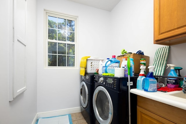 washroom with cabinets, light tile patterned floors, and washing machine and clothes dryer