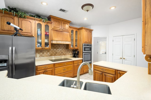 kitchen with appliances with stainless steel finishes, backsplash, custom exhaust hood, sink, and light tile patterned floors