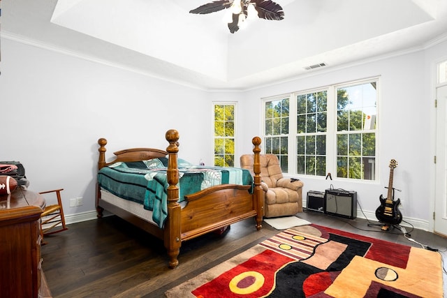 bedroom with dark hardwood / wood-style flooring, a raised ceiling, ceiling fan, and crown molding