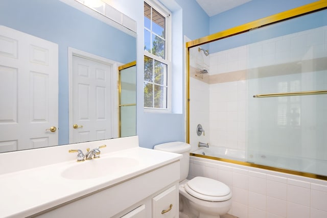 full bathroom with shower / bath combination with glass door, vanity, and toilet