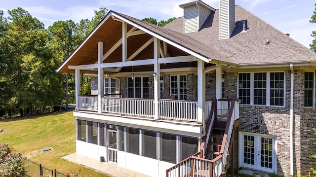 rear view of house with french doors, a yard, and a balcony