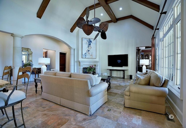 living room featuring beam ceiling, decorative columns, high vaulted ceiling, and ceiling fan