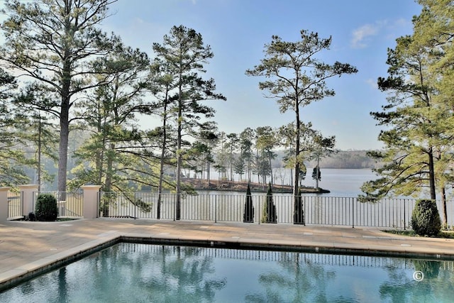 view of swimming pool with a patio and a water view