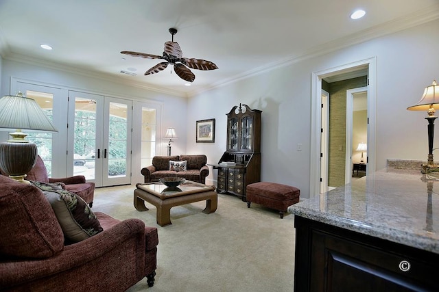 carpeted living room with french doors, ceiling fan, and crown molding