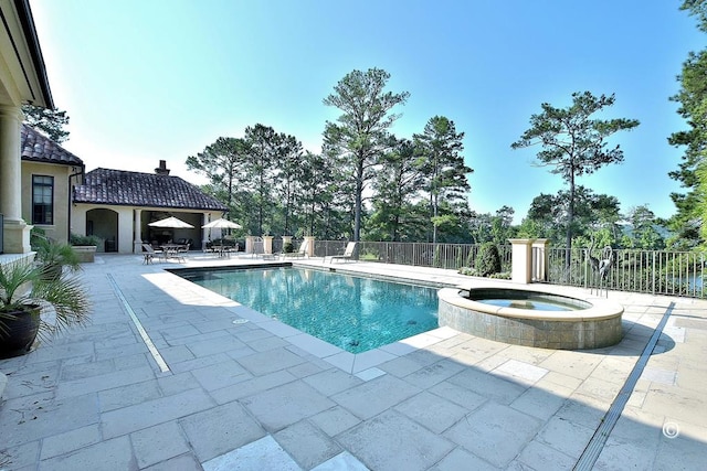 view of swimming pool featuring an in ground hot tub and a patio