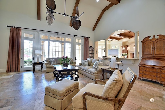 living room featuring ornate columns, ceiling fan, beamed ceiling, and high vaulted ceiling