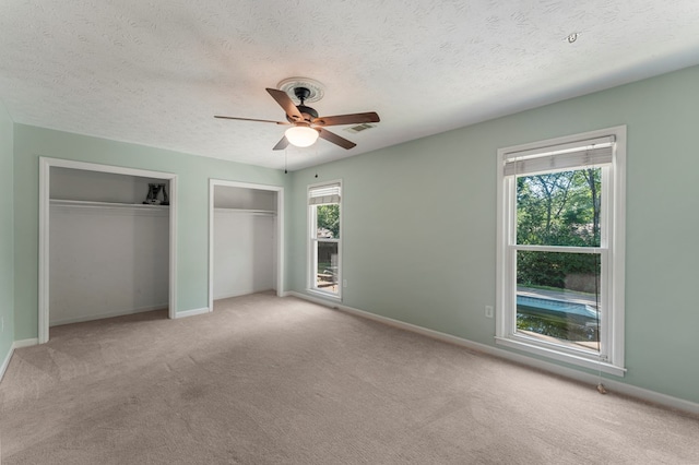 1506 Lokey Dr, Columbus, GA 31904 - unfurnished bedroom featuring two closets, carpet floors, baseboards, and a textured ceiling