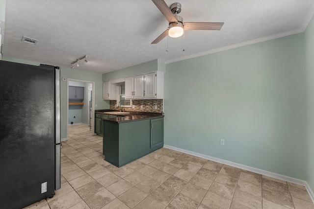 1506 Lokey Dr, Columbus, GA 31904 - kitchen featuring freestanding refrigerator, a peninsula, dark countertops, a ceiling fan, and tasteful backsplash