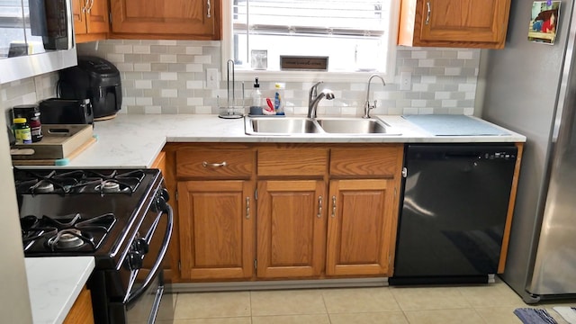 kitchen with light tile patterned floors, sink, decorative backsplash, and black appliances