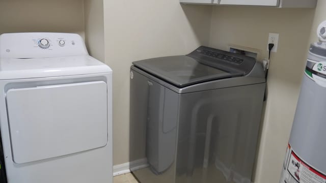 washroom with gas water heater and washer and dryer