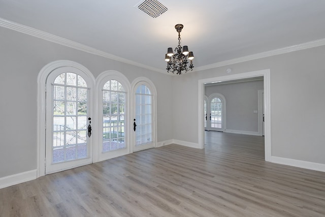 unfurnished room featuring visible vents, wood finished floors, crown molding, and french doors