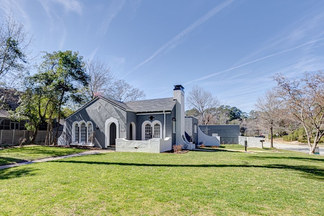 exterior space with a yard, a chimney, fence, and stucco siding