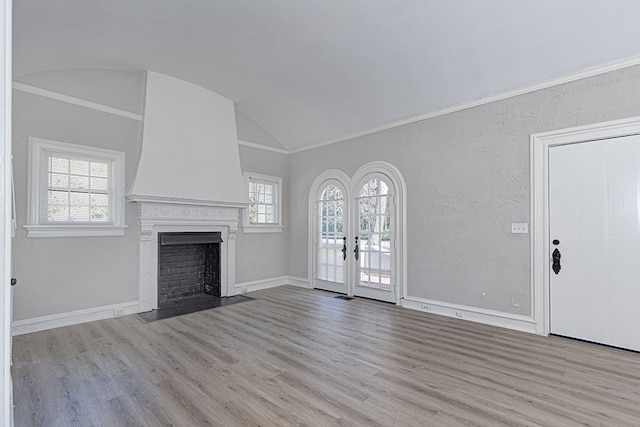 unfurnished living room with baseboards, crown molding, and light wood finished floors