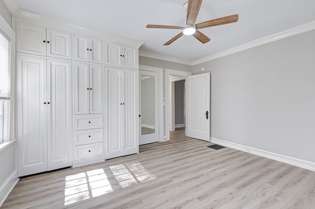 unfurnished bedroom featuring baseboards, light wood-style flooring, ceiling fan, crown molding, and a closet