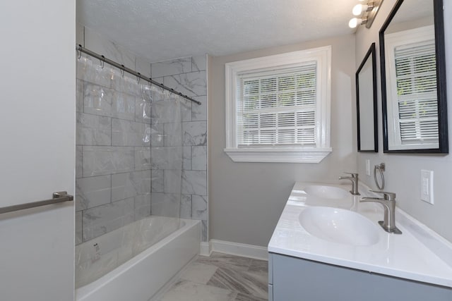 full bathroom featuring a textured ceiling, baseboards, a sink, and shower / bathing tub combination