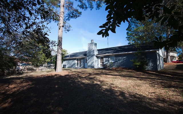 rear view of property featuring a lawn