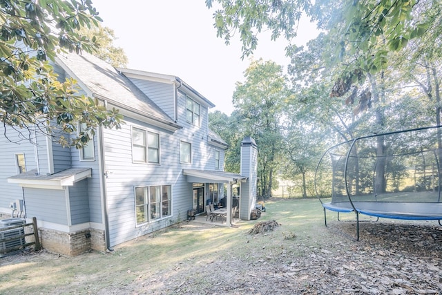 view of yard featuring a patio, central AC unit, and a trampoline