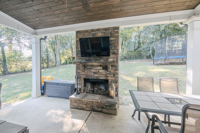 view of patio featuring an outdoor stone fireplace and a trampoline