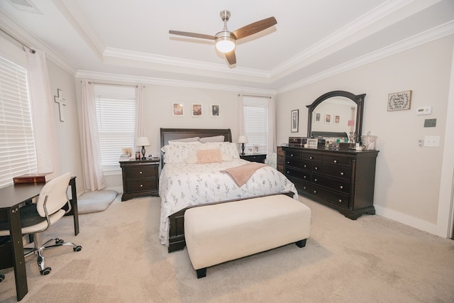 bedroom featuring a tray ceiling, ceiling fan, light colored carpet, and ornamental molding