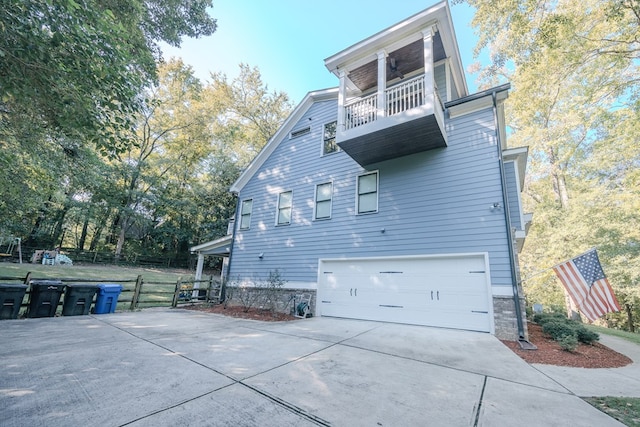 view of side of property with a garage and a balcony