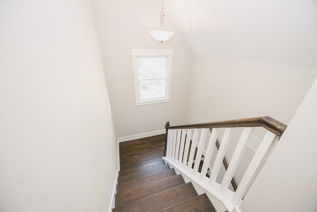 staircase featuring lofted ceiling and wood-type flooring