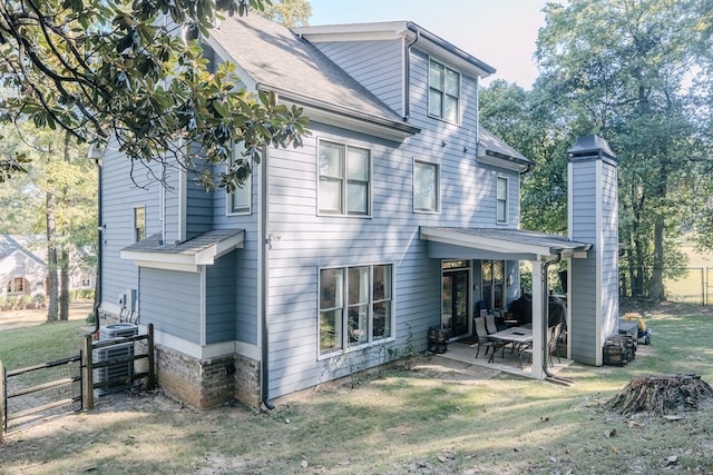 rear view of house featuring a patio area and a yard