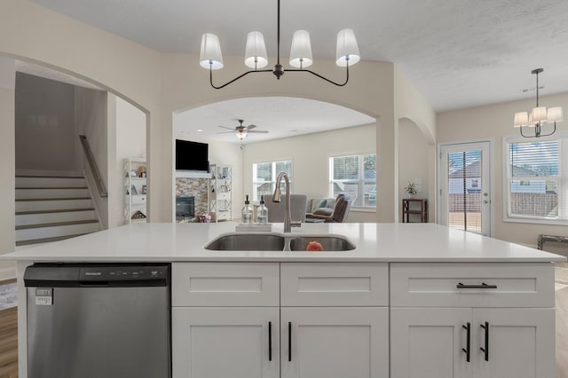 kitchen with sink, white cabinetry, a textured ceiling, a center island with sink, and stainless steel dishwasher