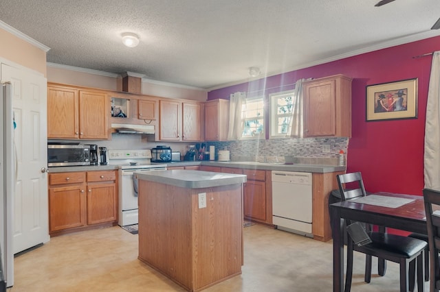 kitchen featuring a center island, backsplash, crown molding, a textured ceiling, and white appliances