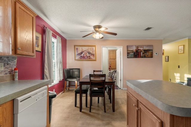 dining space with ceiling fan, ornamental molding, and a textured ceiling