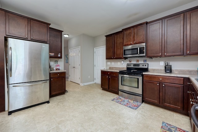 59 Misty Forest Dr, Phenix City, AL 36869 - kitchen featuring appliances with stainless steel finishes, light countertops, dark brown cabinets, and baseboards