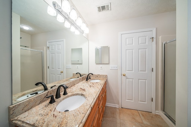 4021 Shade Valley Dr, Columbus, GA 31909 - full bathroom with double vanity, a shower stall, tile patterned flooring, and a textured ceiling