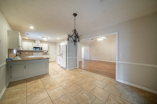 4021 Shade Valley Dr, Columbus, GA 31909 - kitchen featuring white appliances, a peninsula, backsplash, open floor plan, and a textured ceiling