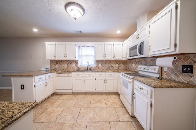 4021 Shade Valley Dr, Columbus, GA 31909 - kitchen featuring white appliances, a peninsula, tasteful backsplash, white cabinets, and recessed lighting