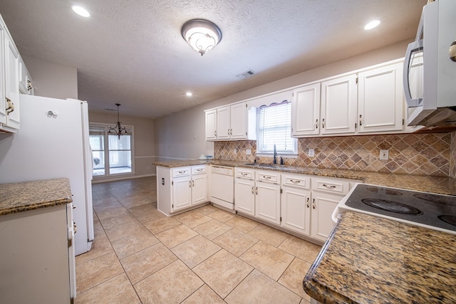 4021 Shade Valley Dr, Columbus, GA 31909 - kitchen with white appliances, a peninsula, white cabinetry, recessed lighting, and a textured ceiling