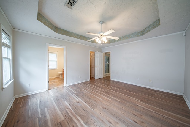 4021 Shade Valley Dr, Columbus, GA 31909 - unfurnished bedroom featuring a textured ceiling, a tray ceiling, hardwood / wood-style flooring, connected bathroom, and crown molding