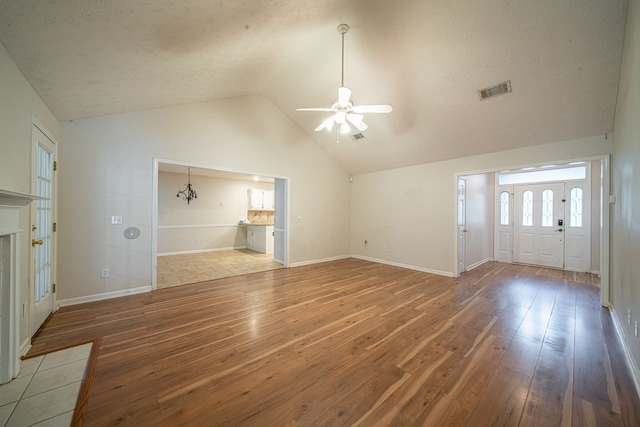 4021 Shade Valley Dr, Columbus, GA 31909 - unfurnished living room featuring wood-type flooring, a ceiling fan, lofted ceiling, a textured ceiling, and a tiled fireplace