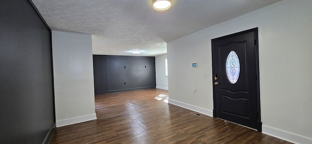 entrance foyer with dark wood-type flooring and a textured ceiling