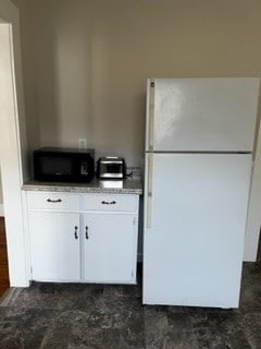 kitchen featuring white cabinets and white refrigerator