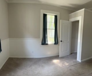 carpeted spare room with crown molding