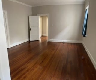 empty room featuring dark hardwood / wood-style floors and ornamental molding