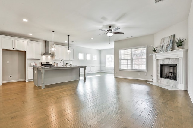 living room featuring ceiling fan, dark hardwood / wood-style flooring, a high end fireplace, and sink