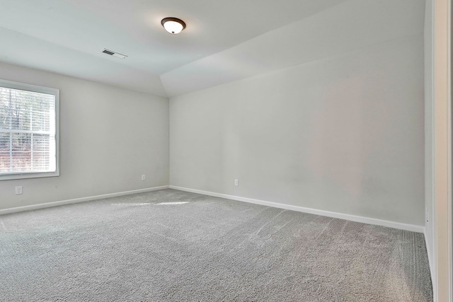 carpeted spare room featuring lofted ceiling