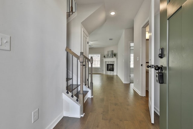 foyer entrance with a high end fireplace, dark hardwood / wood-style flooring, and ceiling fan