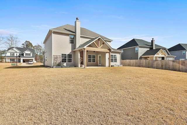 rear view of house featuring a lawn and a patio