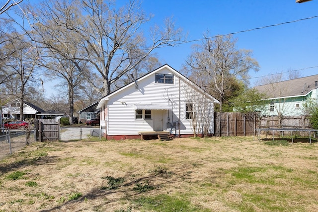 2418 34th St, Valley, AL 36854 - rear view of house featuring a trampoline, a fenced backyard, and a yard