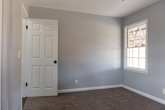 carpeted spare room featuring baseboards